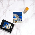 Sam Gilliss Visual Arts Santorini Blue Domes puzzle showing a vibrant image of iconic blue-domed churches in Oia, Greece, with 110 to 1000 pieces.